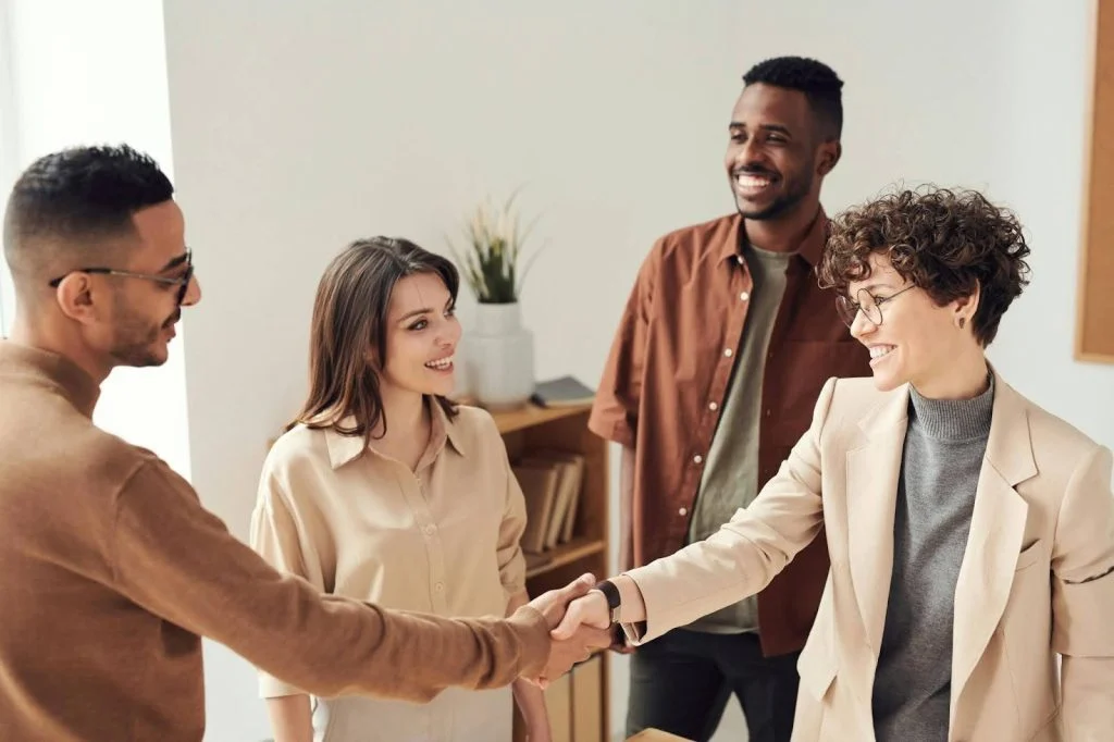 women in suit shaking hand with a man